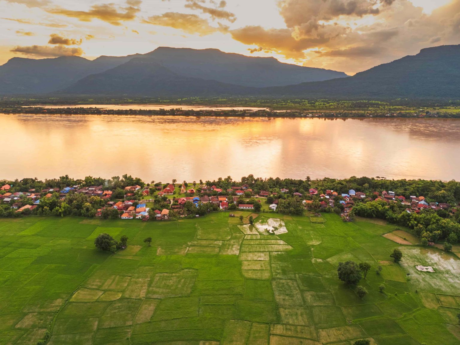 Village roofs, fields and the river in the last light of day.