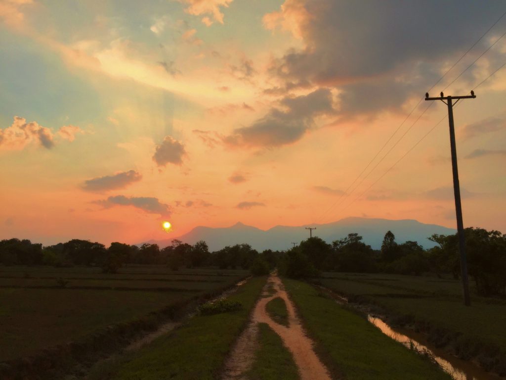 An island track beneath an orange and pink evening sky.