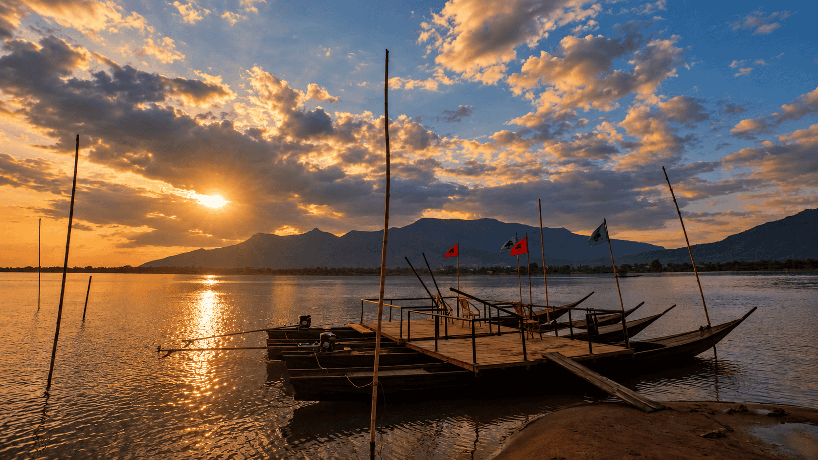 Boats rest on the river beneath the colours of sunset.